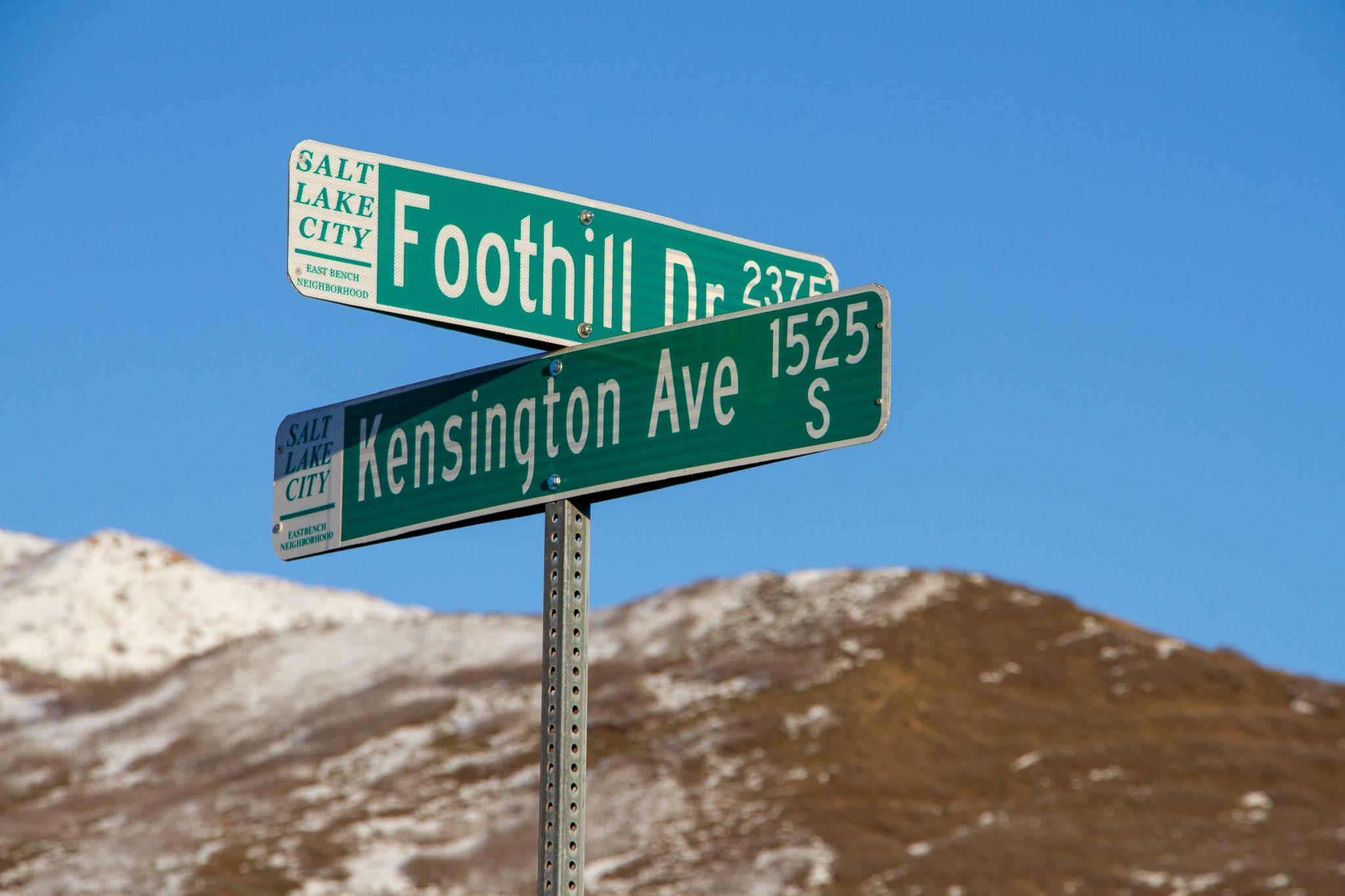 A close up picture of the street signs marking the intersection of Foothill Drive and Kensington Avenue.
