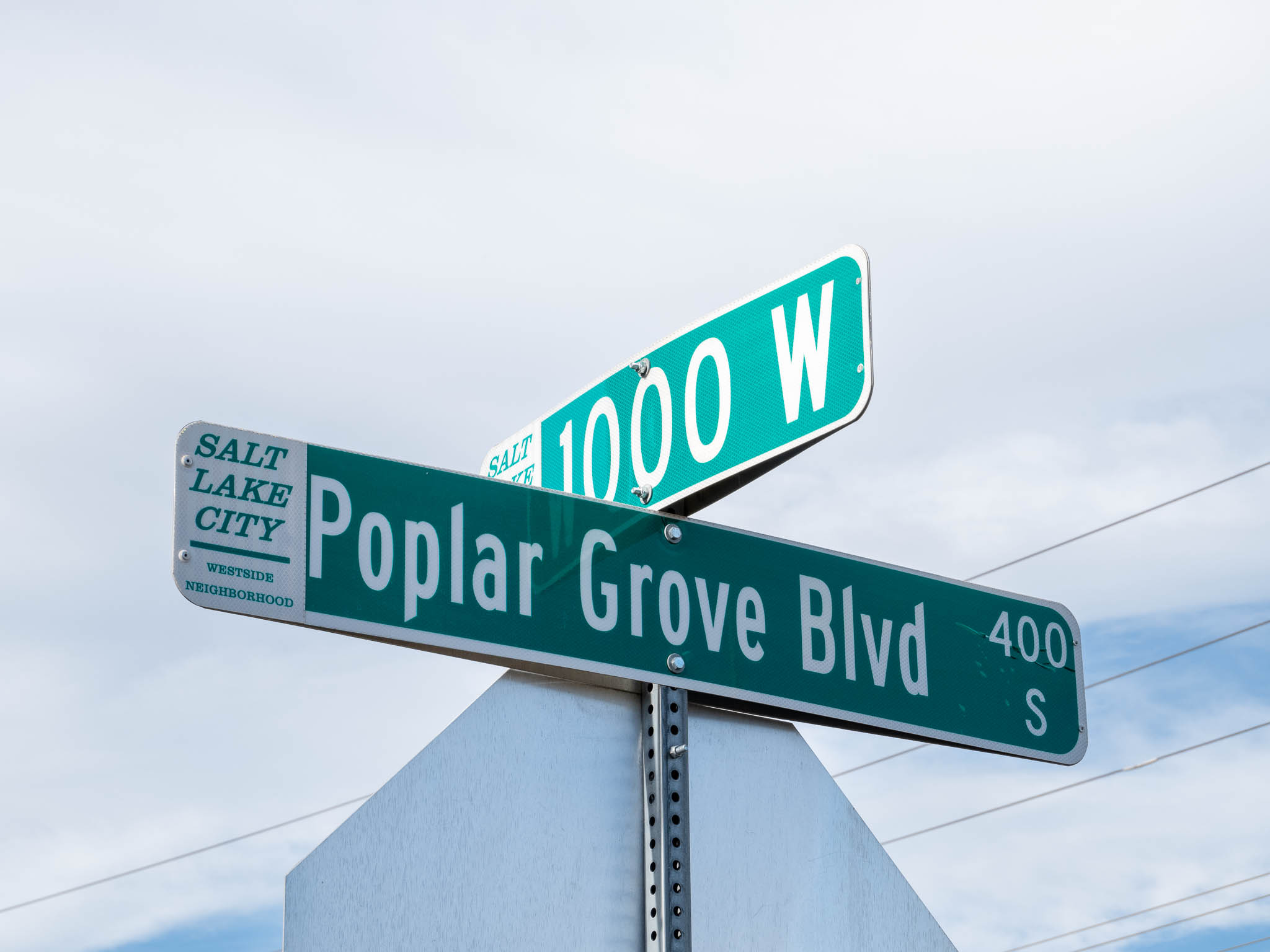 A photo of the street name signs at the intersection of 1000 West and Poplar Grove Boulevard.
