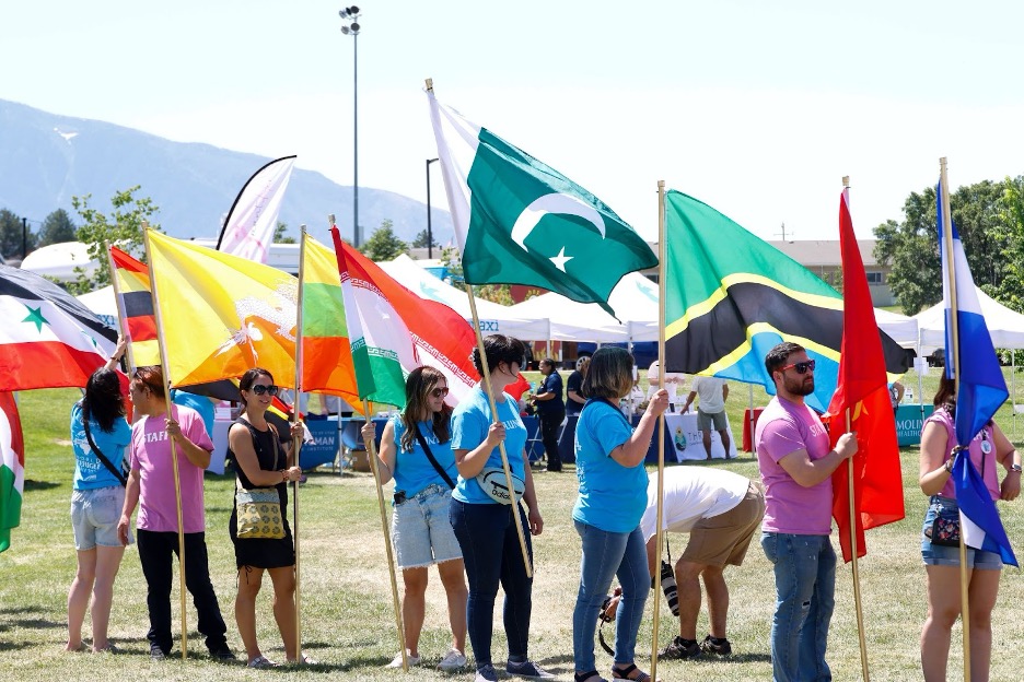 An image of 2024 World Refugee Day attendees holding flags from different countries