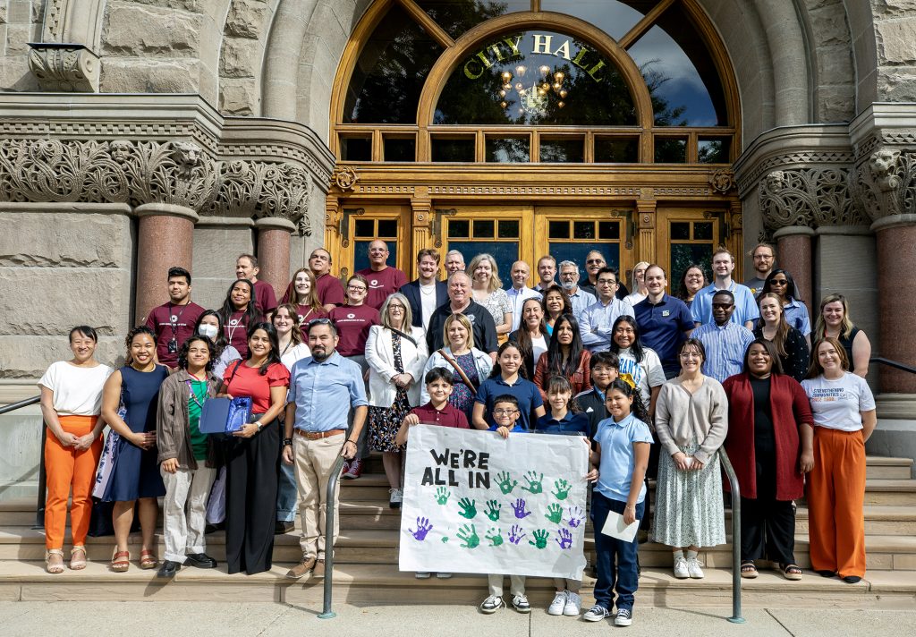 A group of people gathered at City Hall in Salt Lake City during the 2024 Welcoming Week celebration.