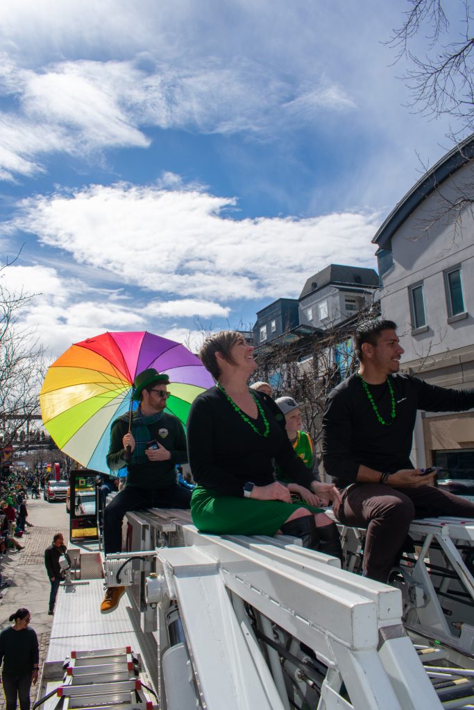 Council Member Alejandro Puy and other Salt Lake City Council Members riding on a fire truck during the St. Patrick's Day Parade