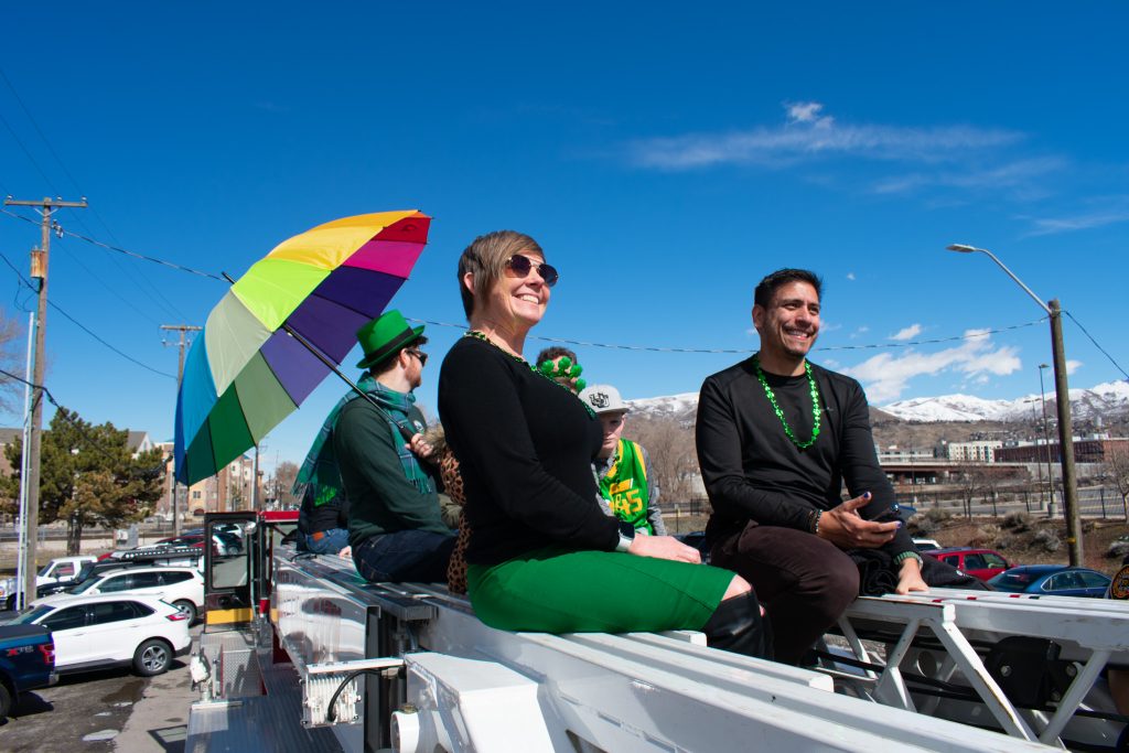 Council Member Alejandro Puy and other Salt Lake City Council Members riding on the top of a fire truck at the 46th annual St. Patrick's Day Parade