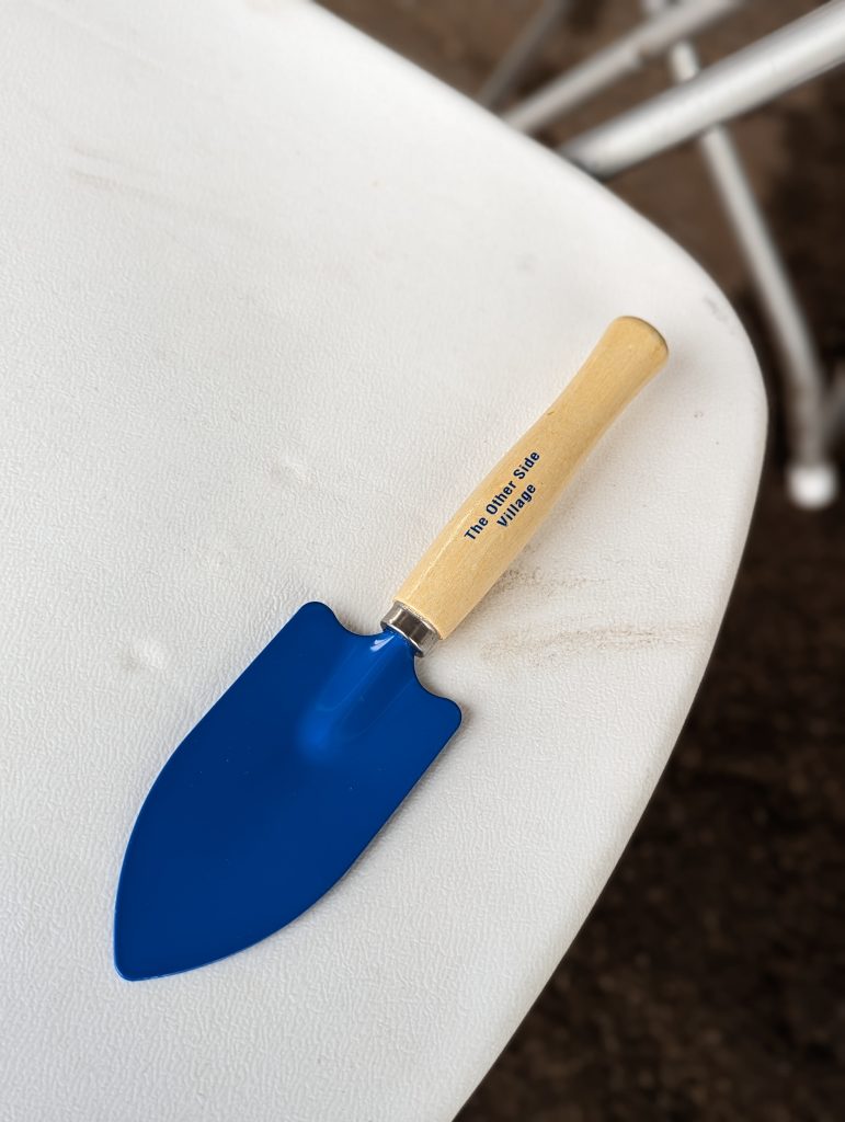 A blue shovel lying on a white chair.