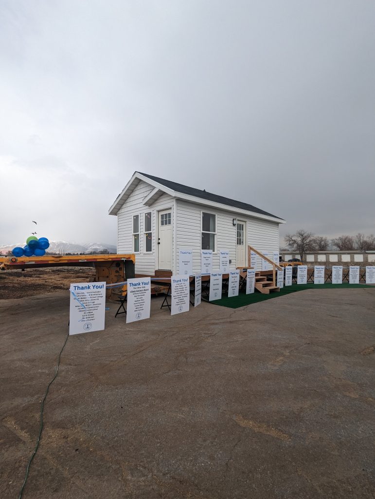 A tiny home with thank you signs around it.