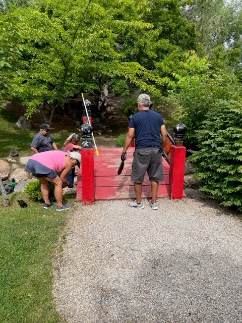 People inspecting and sweeping the red bridge.