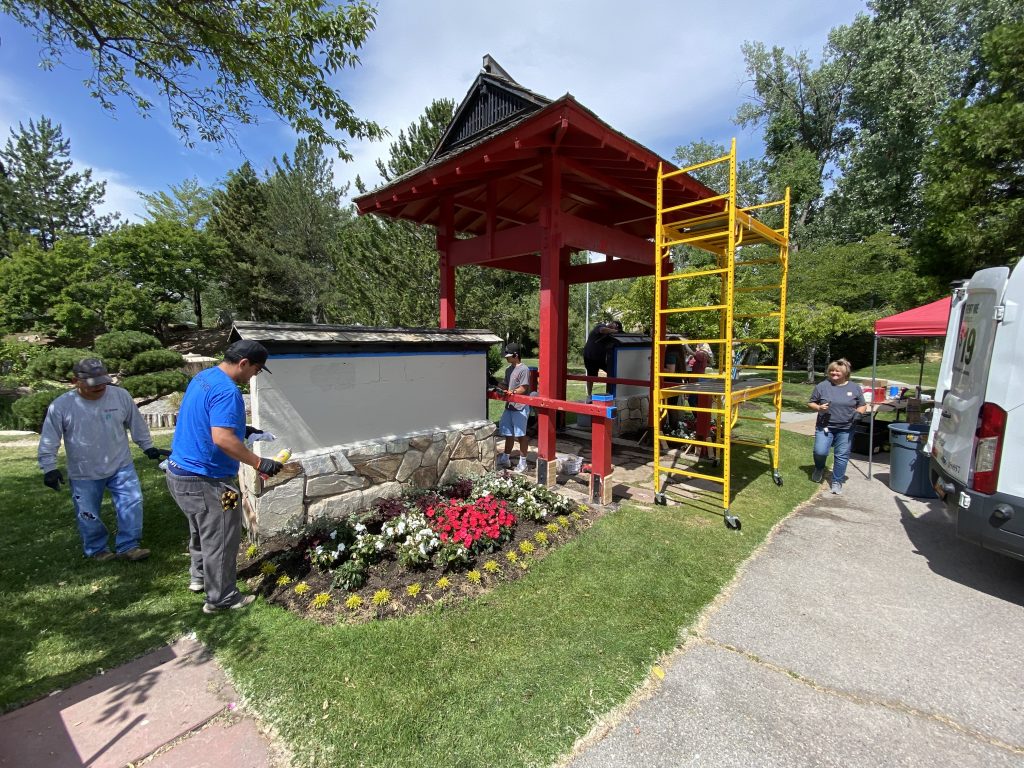 People painting the gateway and the half-walls on either side of it.