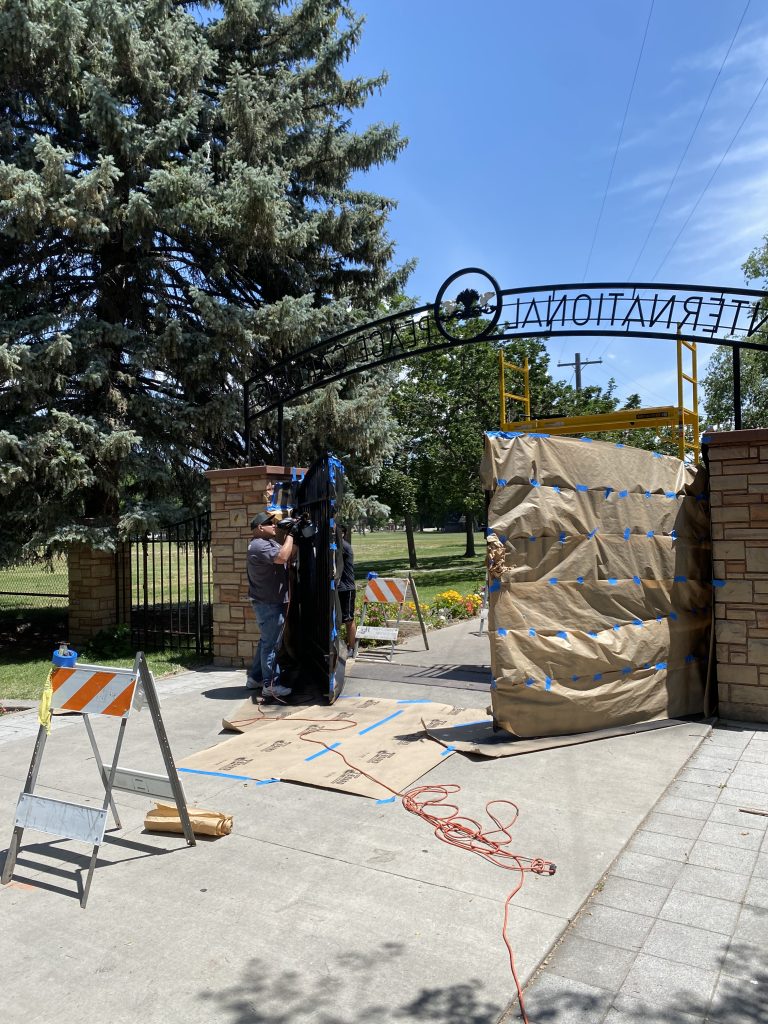 A man working on the gates to the International Peace Gardens.