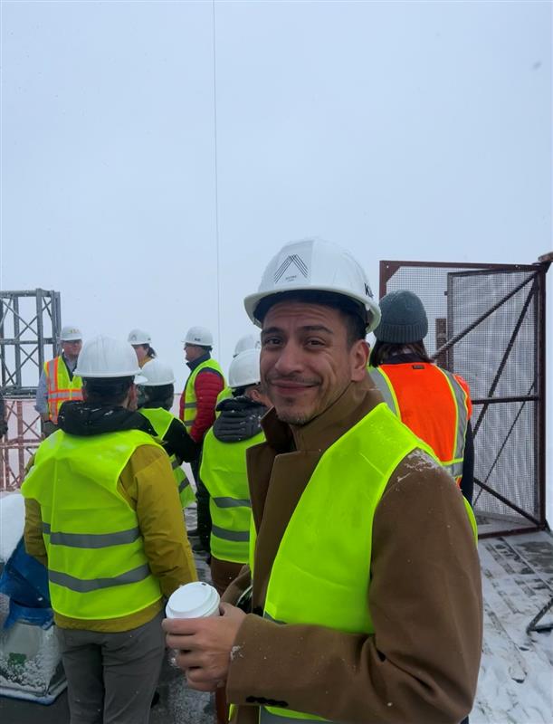 District 2 Council Member Alejandro Puy with others touring the top of Astra Tower while wearing hard hats and reflective vests.