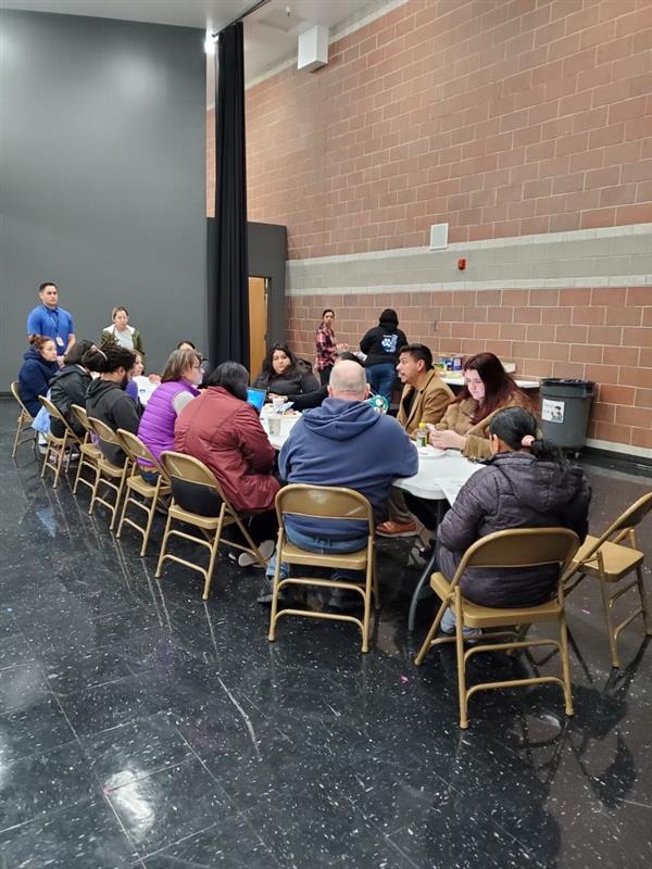 View of District 2 Council Member Alejandro Puy sitting at a table with 13 people from the Parkview Elementary School Community Council.