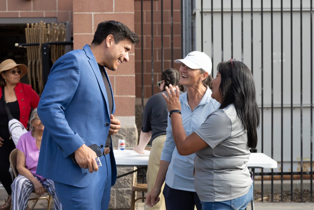 Council Member Puy talking with two people.