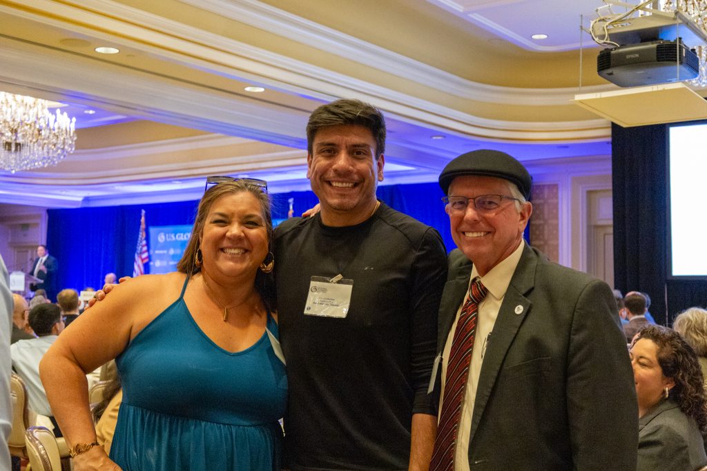 Three people pose for photo.