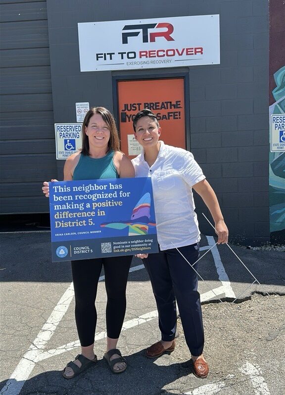 Vickie Shaw, owner of Fit to Recover, with Council Member Erika Carlsen holding a sign that reads, "This neighbor has ben recognized for making a positive difference in District 5."
