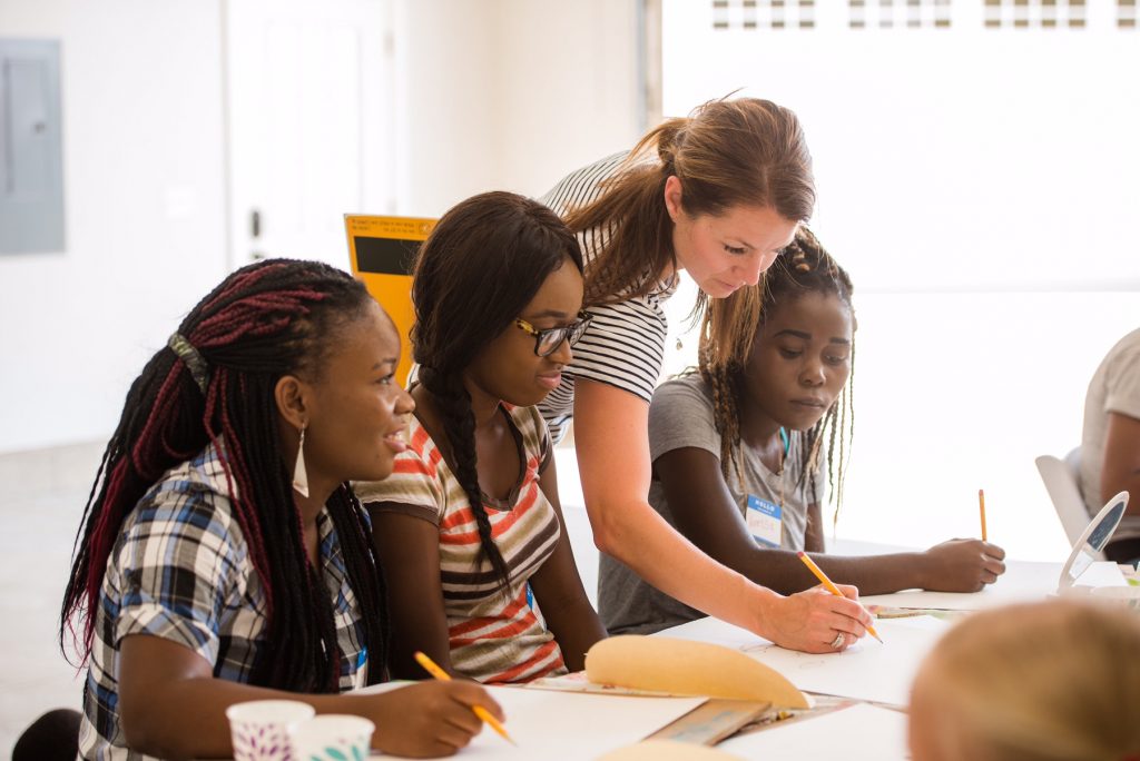 Several students and a teacher in a classroom setting 