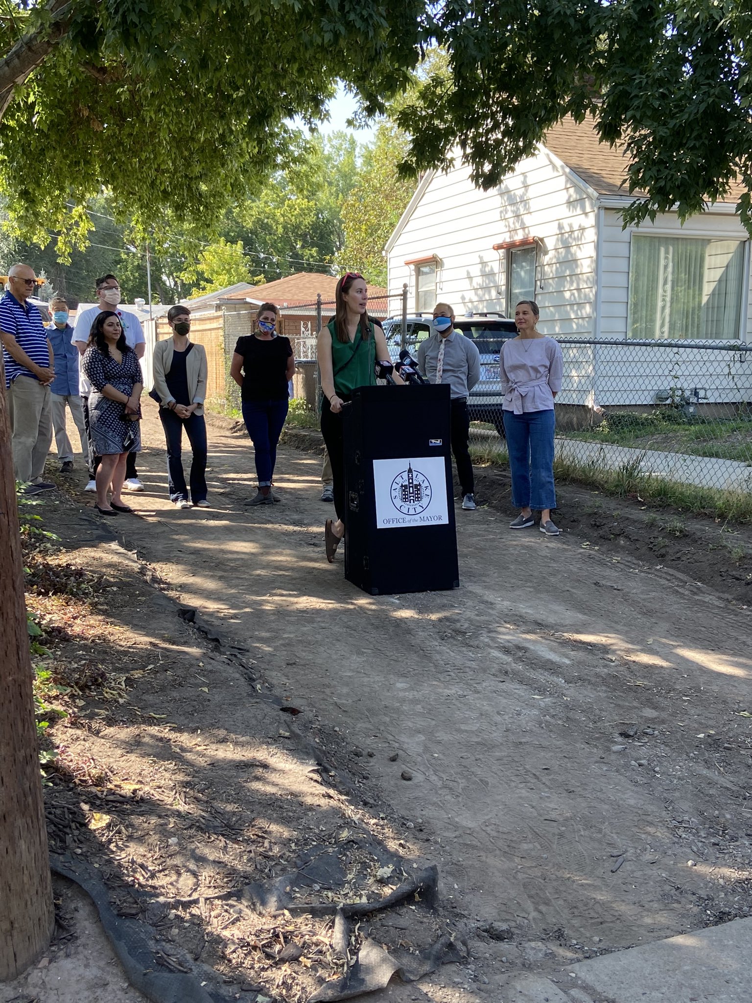 A group of people speaking at a podium about the alleyway pilot program.