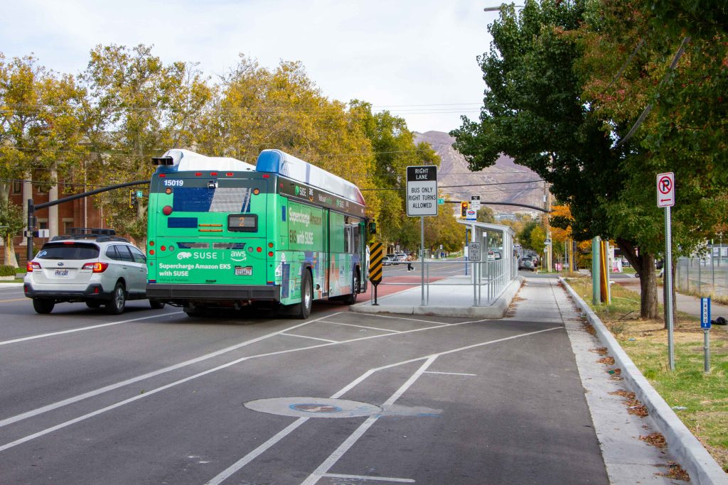 A picture of a bus stopped at a bus boarding island.