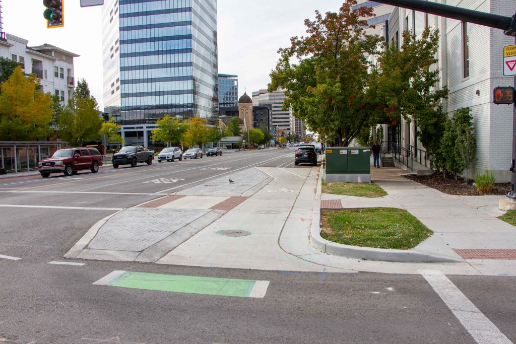 A picture of the bike lane on 200 South which is protected by a curb at an intersection.