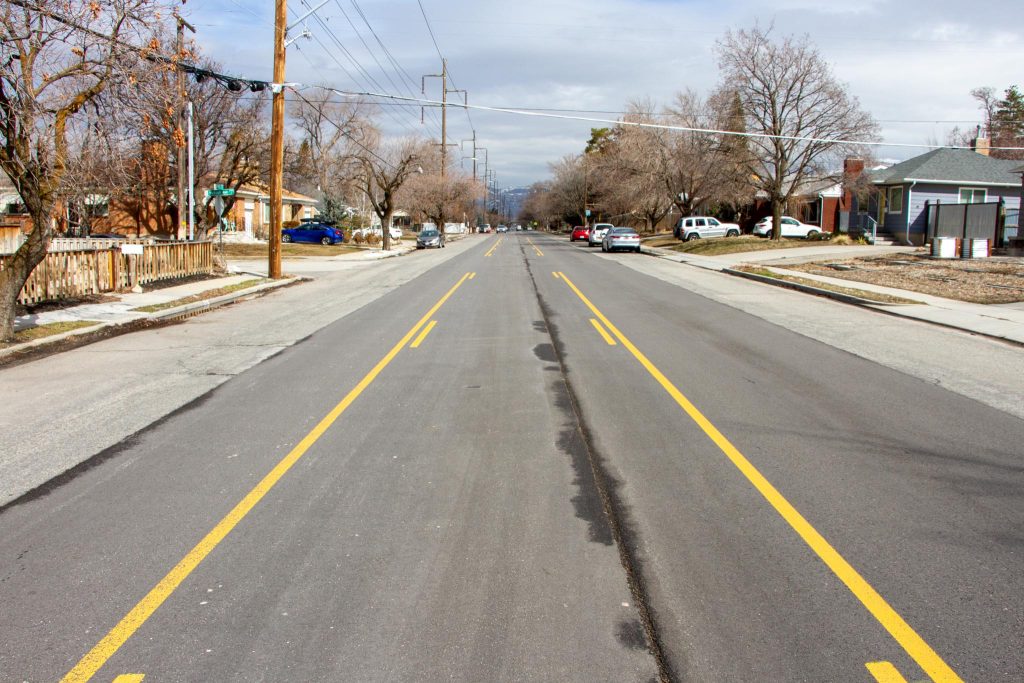 900 East existing conditions looking north. There are two vehicle travel lanes, one in each direction, separated by a two way left turn lane. 