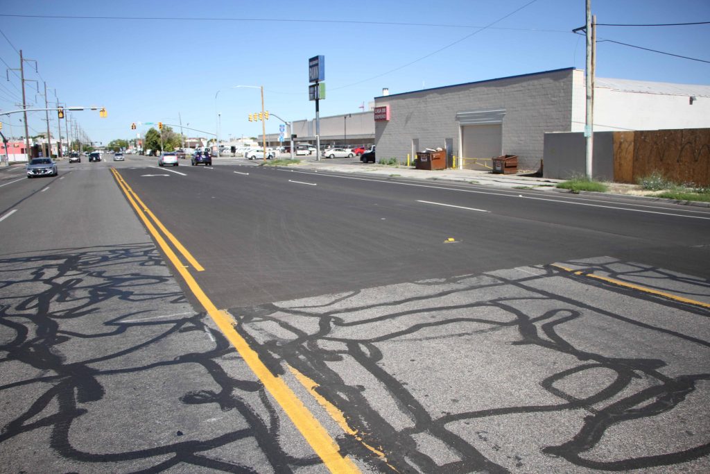 A fresh section of asphalt pavement surrounded by existing pavement on 800 South. This is part of an inlay project to prepare for a surface treatment project. 