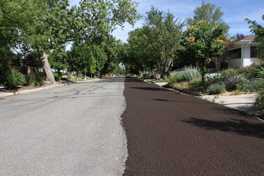 A road with a fresh coat of slurry seal on one side.