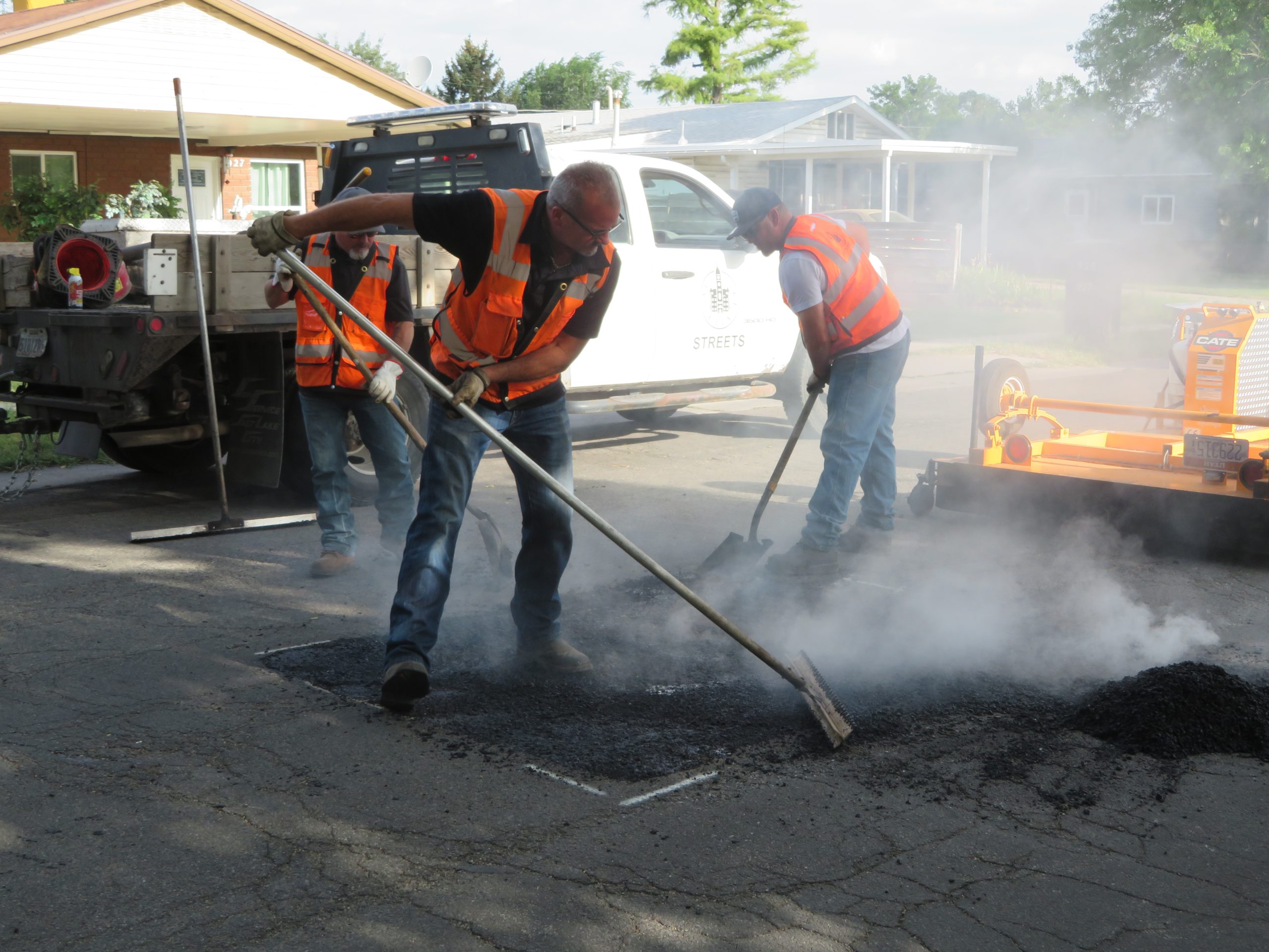Raking up heated asphalt to reuse when repairing the road