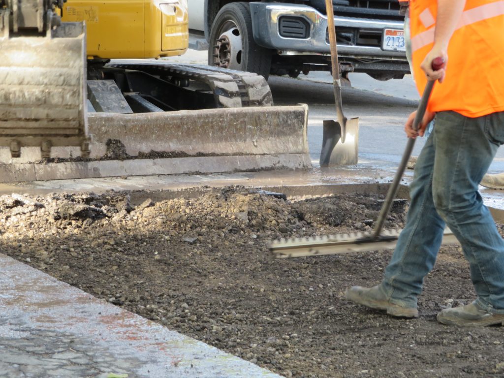 Leveling out the area below the road surface with reclaimed milling material