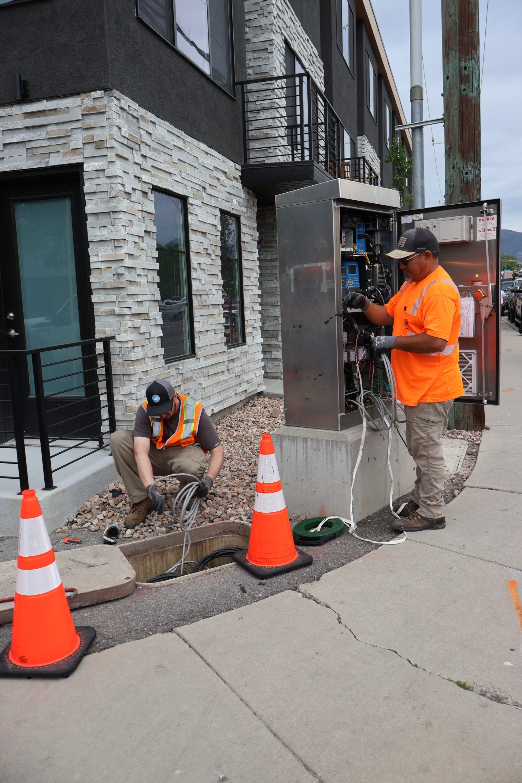 Streets Signal Team working on underground wiring and cabinet that houses the technology to operate a traffic signal.