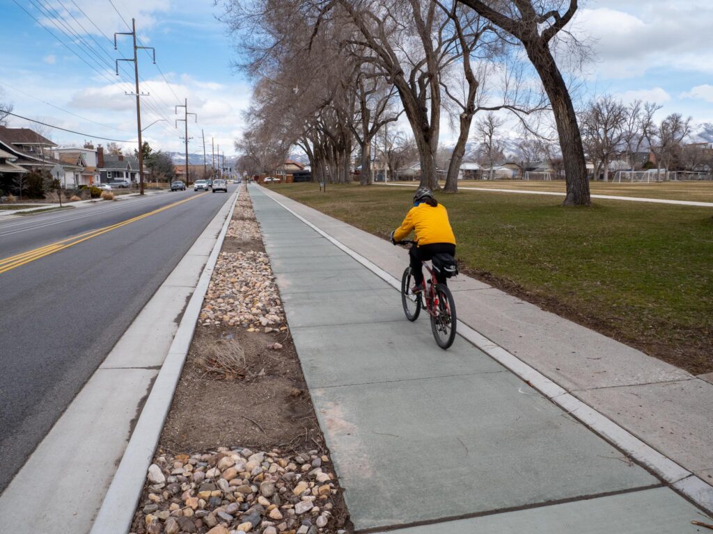 A cyclist riding along the protected bike lane on 900 East near Fairmont Park.