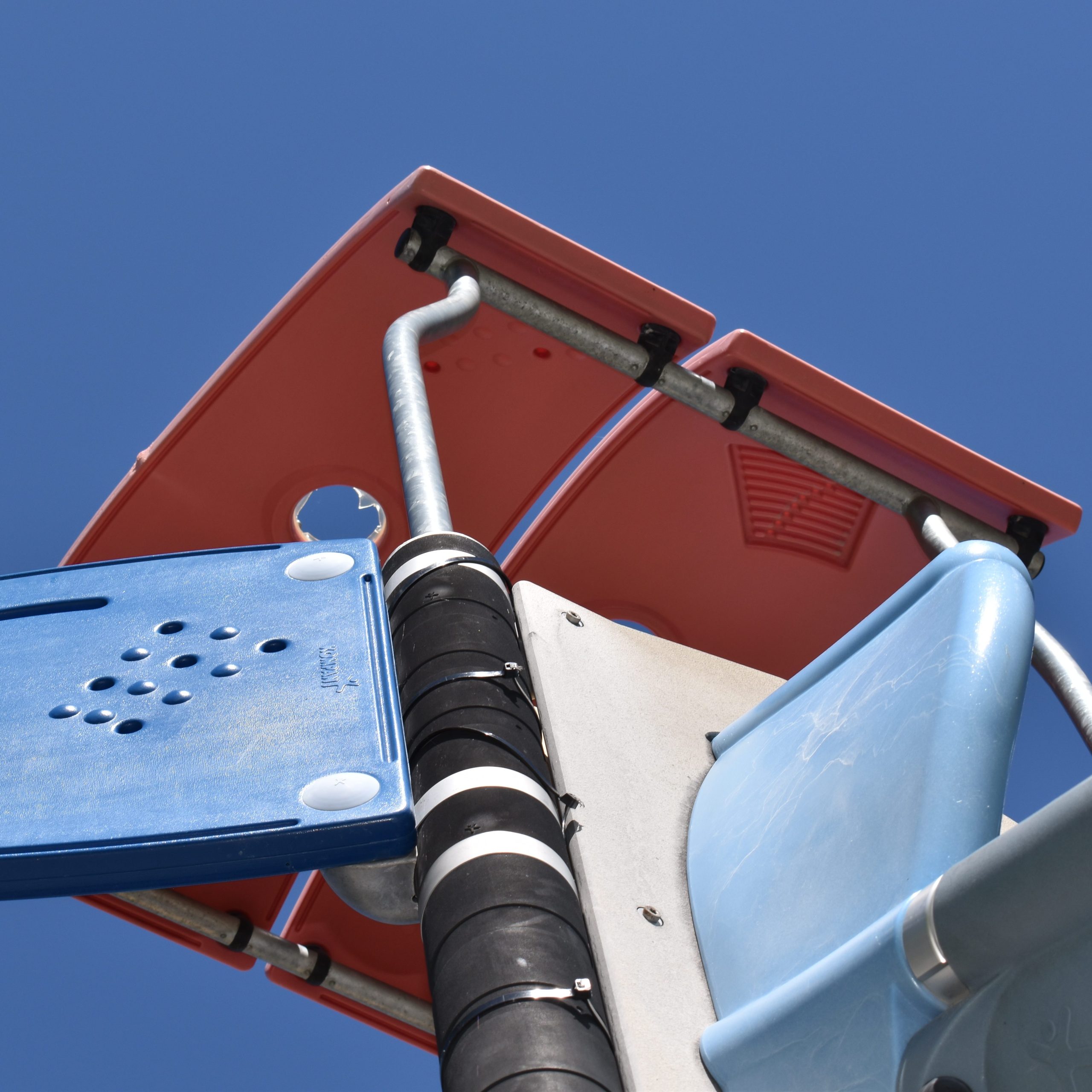 Photo shows playground equipment in front of a blue sky