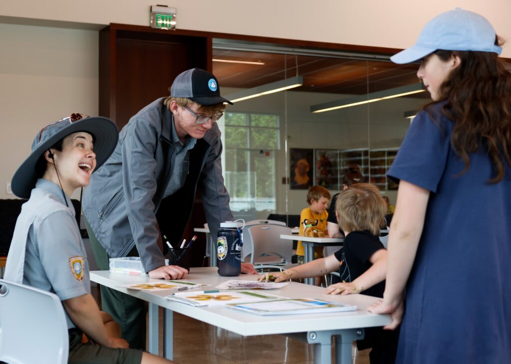 park rangers smile, talking to constituents. 