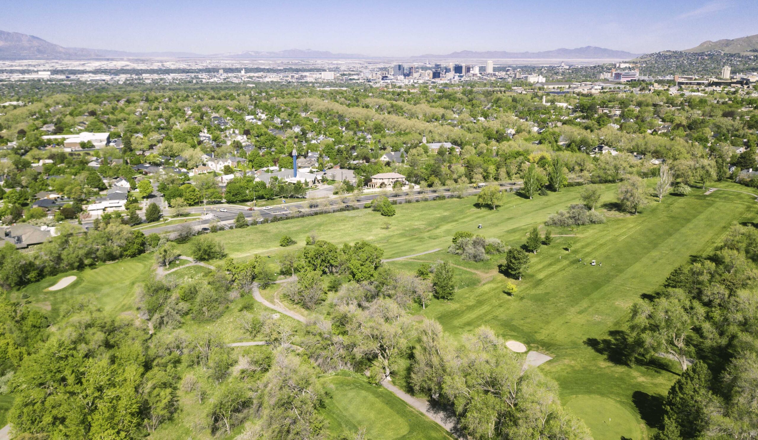 arial view of a golf course showing both the course and the surrounding city. 