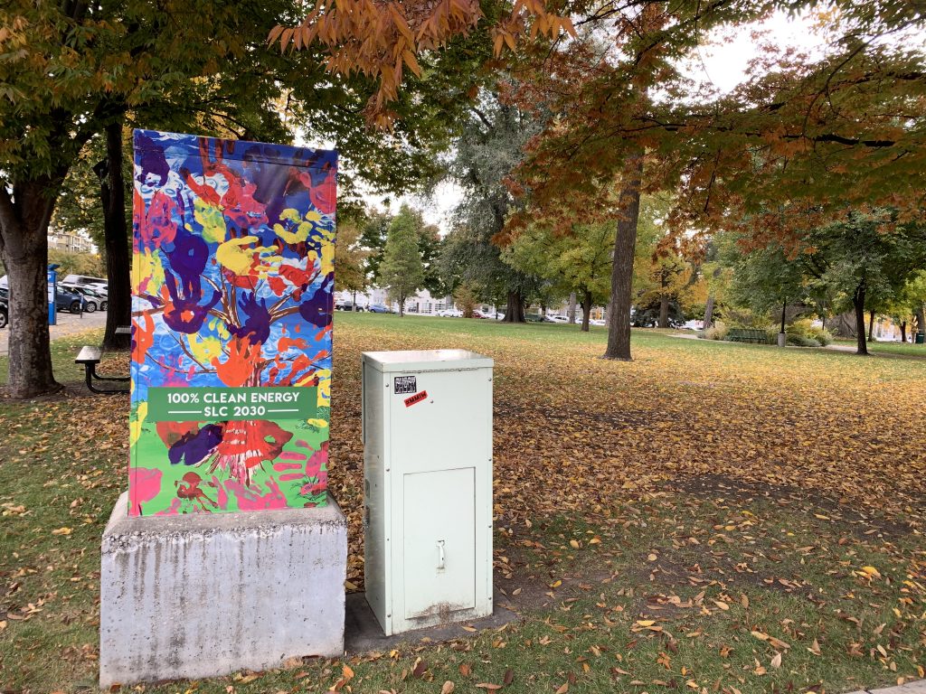 Photograph of Salt Lake City utility box outside of City & County building painted by local students with the SLC goal of 100% clean energy by 2030.