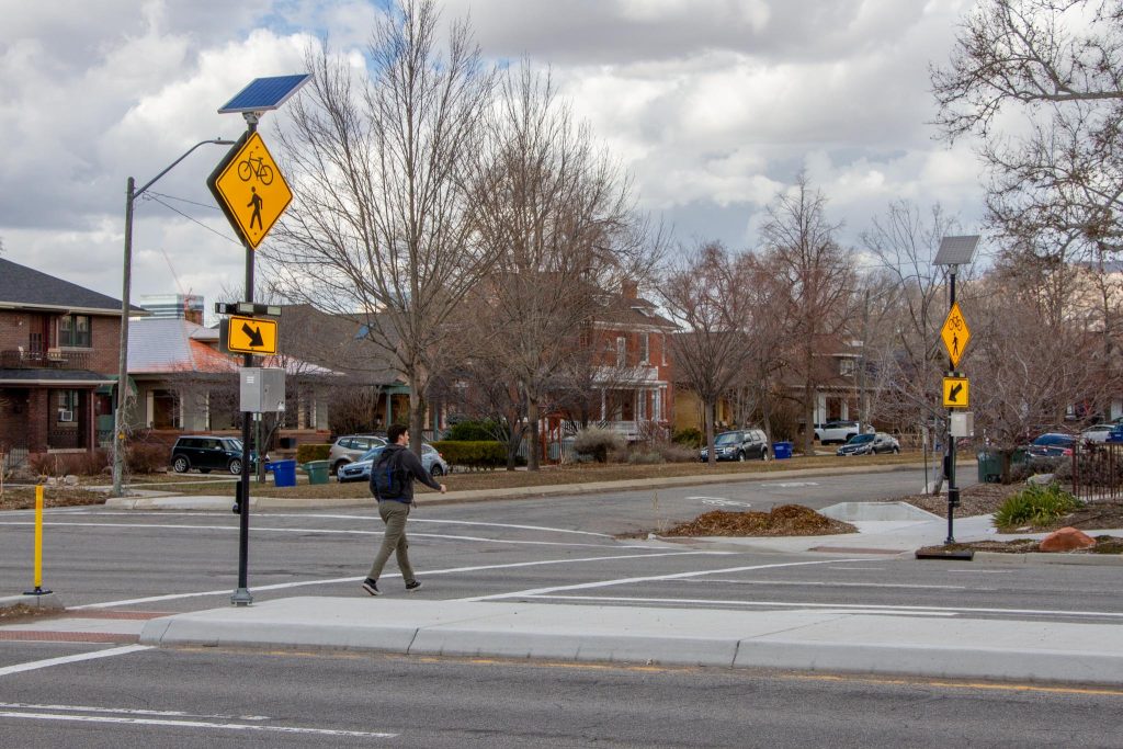 A person using the pedestrian refuge island in the crosswalk at 600 East and 800 South