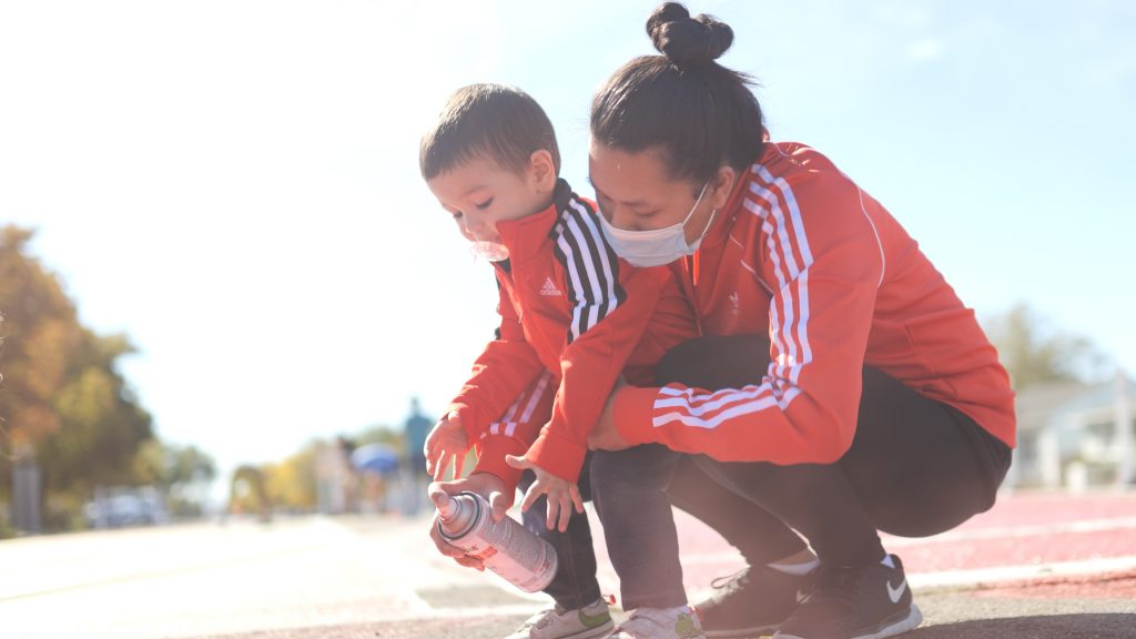 A woman and child painting the pavement.