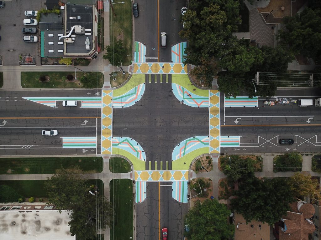 An aerial view of an intersection with painted crosswalks and curb extensions.