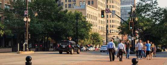 A group of people walking along Main Street at the crosswalk on 300 South in downtown Salt Lake City.