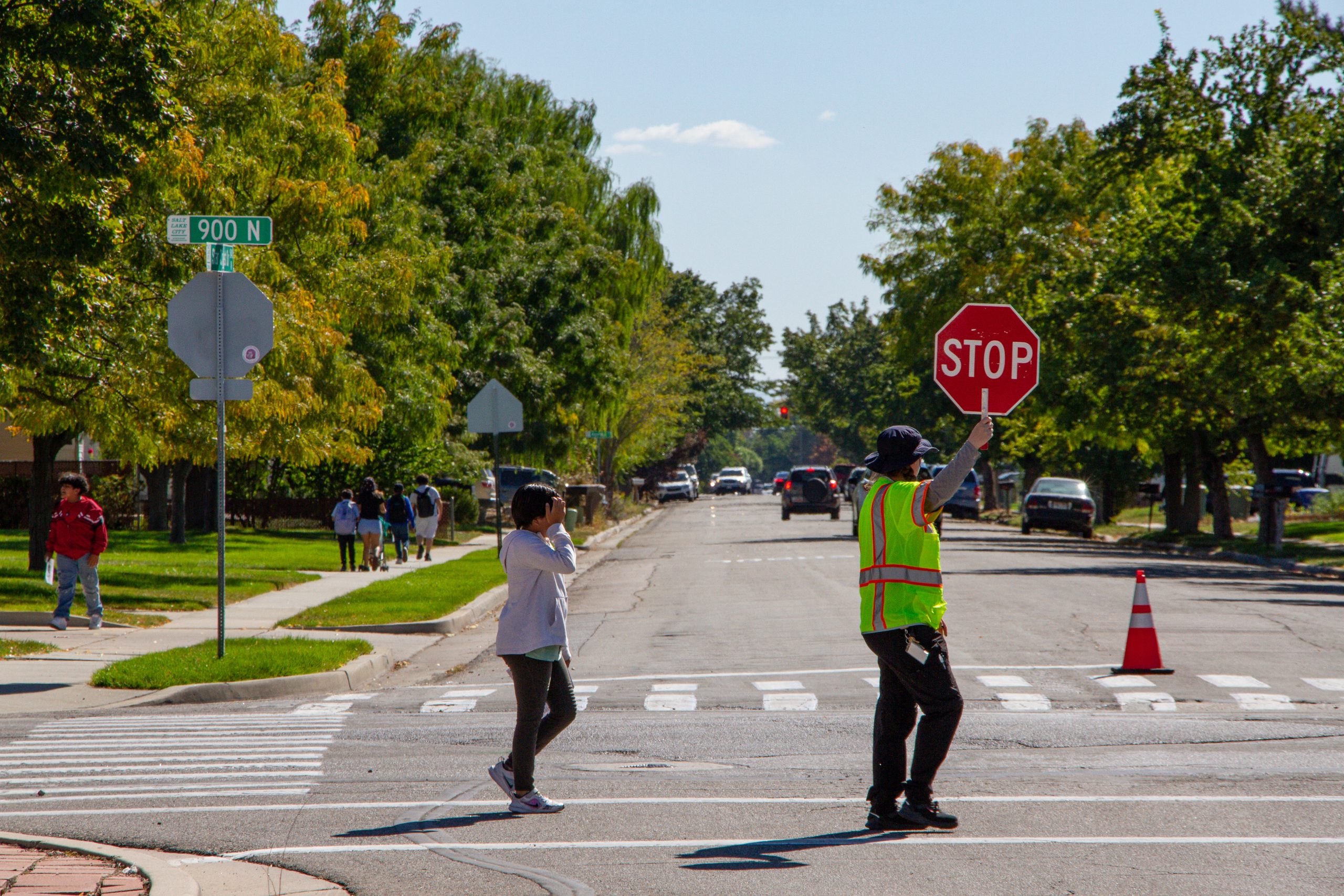 A picture of a crossing guard helping a student cross Star Crest Drive.