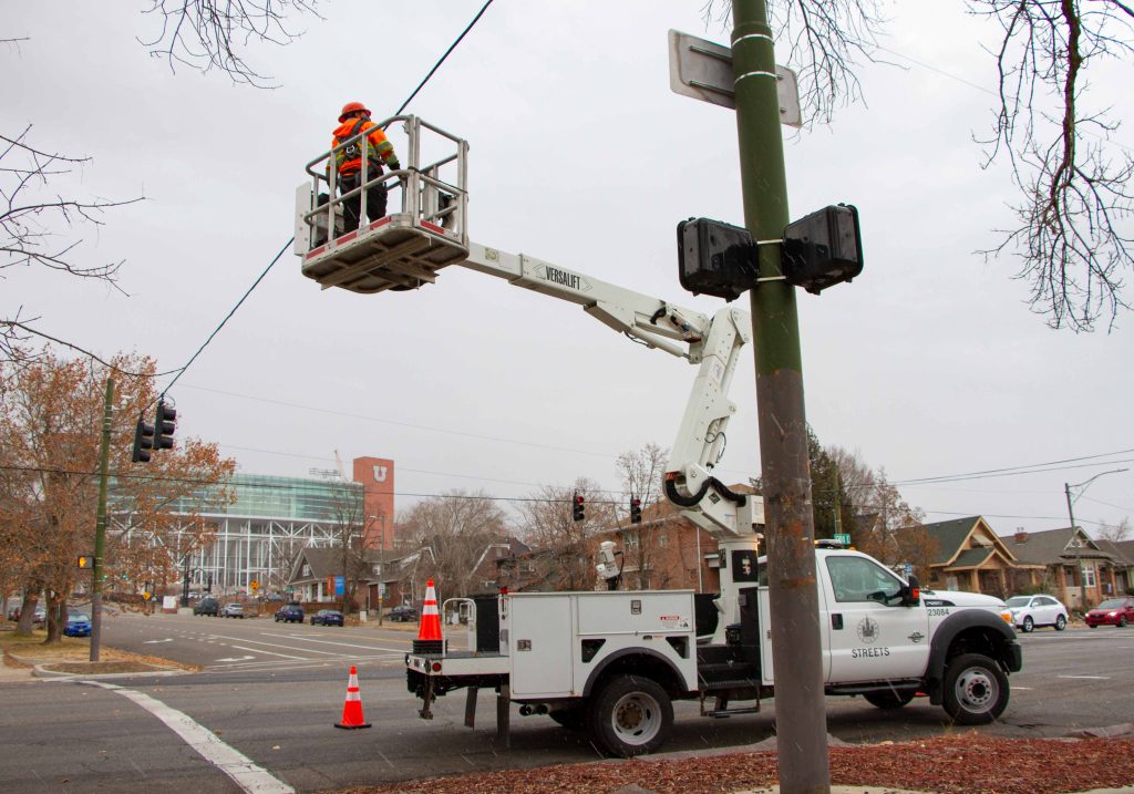 A traffic signal technician doing a periodic maintenance inspection on a span wire traffic signal.