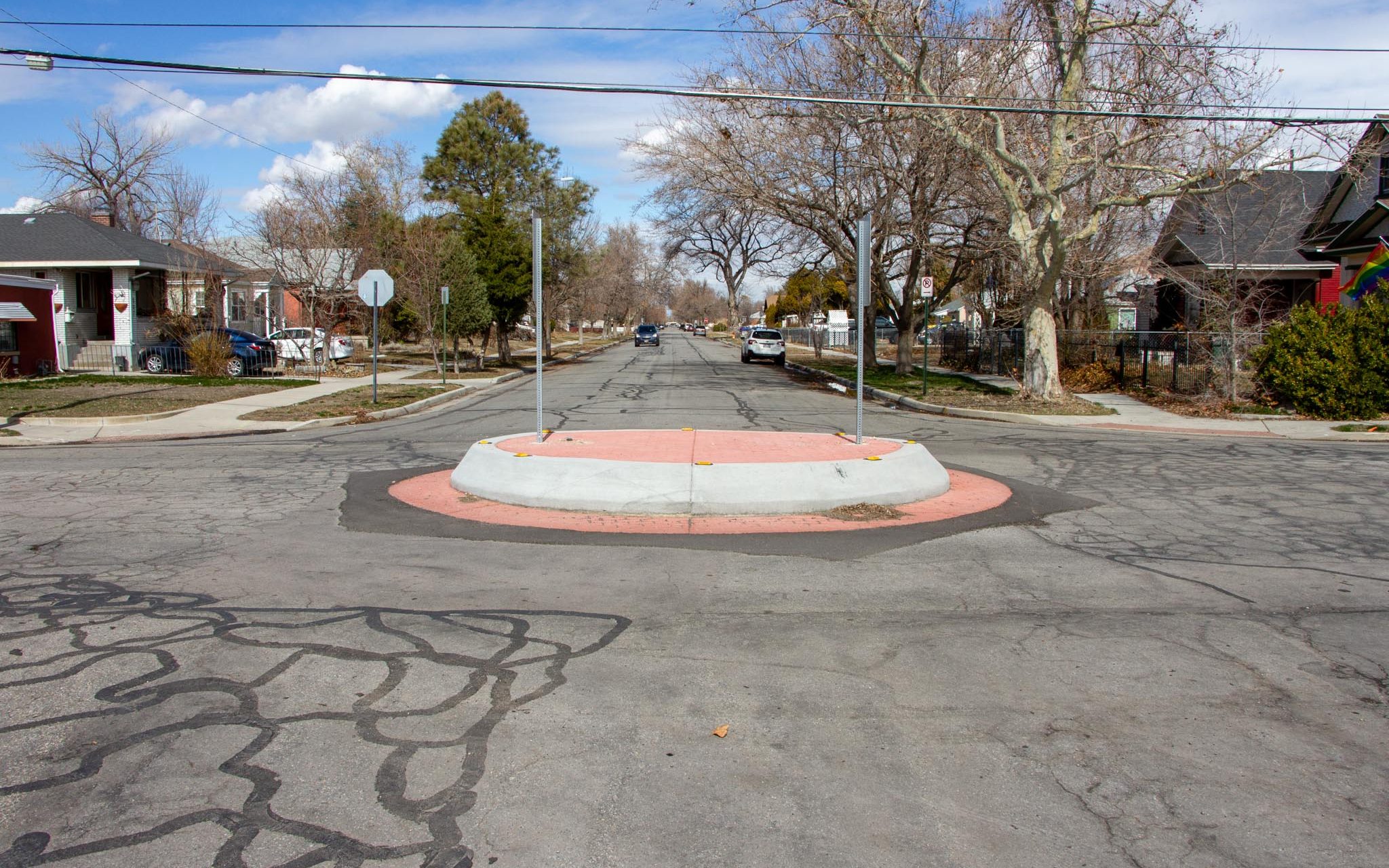 A concrete traffic circle on 500 North in the Fairpark neighborhood. The traffic circle has red stamped concrete to improve its visibility and aesthetic appeal. There are traffic circle signs posted in the middle on both sides of the traffic circle.
