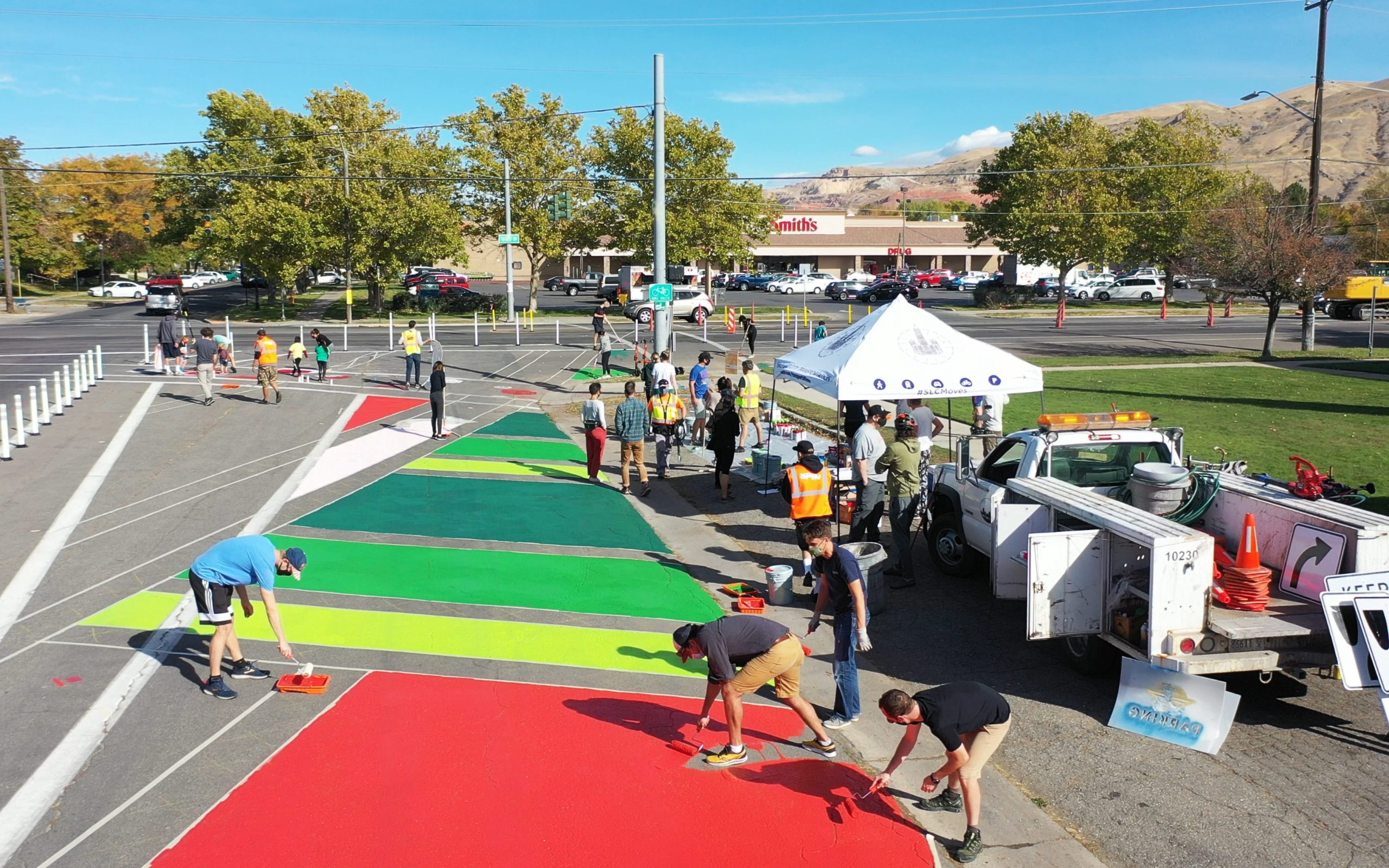 A picture of an asphalt painting project in the Fairpark neighborhood. Residents are painting a colorful mural on the street where the road previously went, before a lane reconfiguration project.