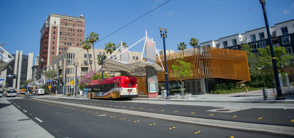 An image of a bus stopped at a beautiful bus hub with modern architecture. 