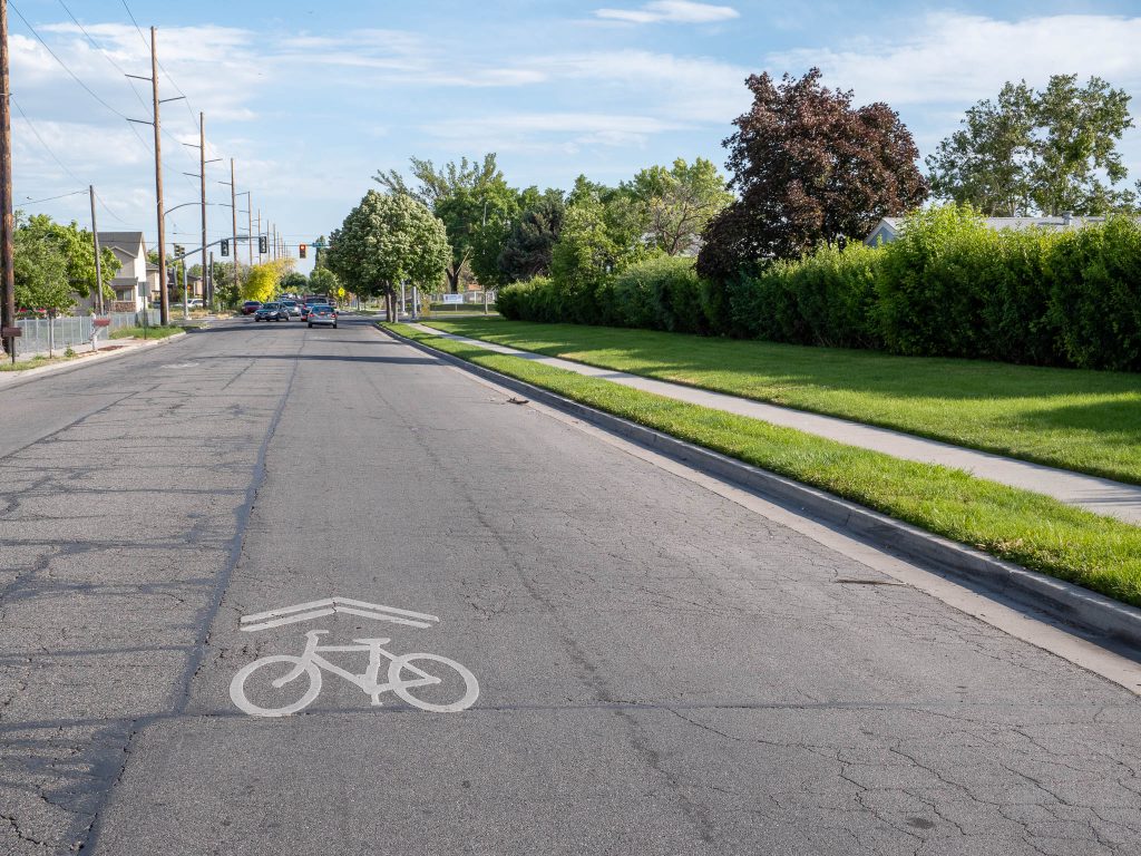 A picture of Cheyenne Street north of 400 South. The street has bicycle shared lane markings and a sidewalk that runs along beautiful landscaping.