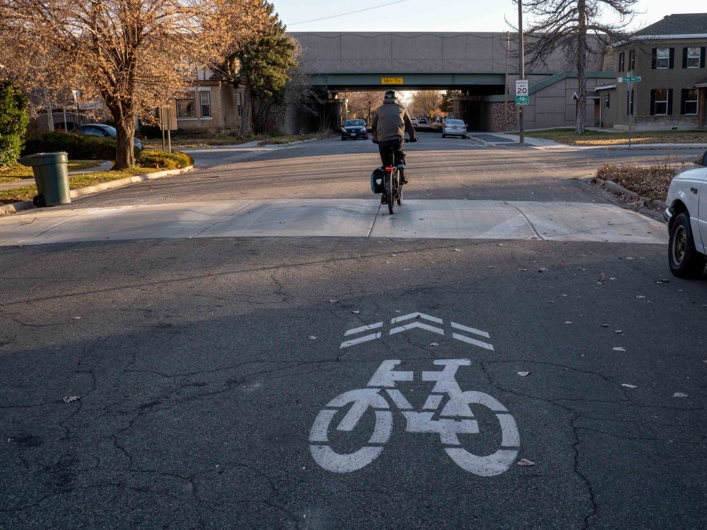 A picture of person riding a bicycle over a speed hump on 600 East.
