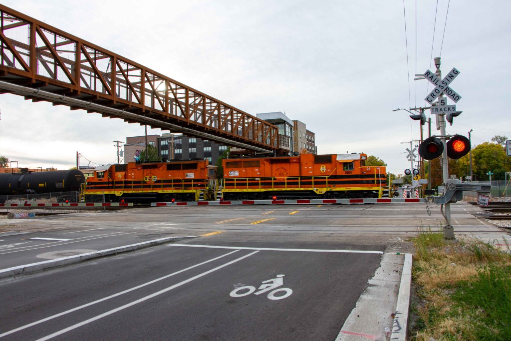 A picture of a freight train passing underneath the 300 North bridge.