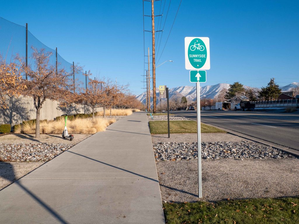 A shared use path on Sunnyside Avenue with a green and white sign that reads "Cycle the City."