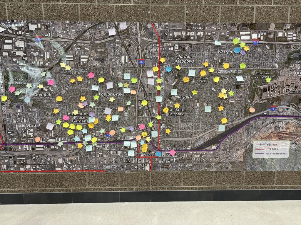 A large map of the West Side on the wall, covered in sticky notes that identify barriers and suggest solutions.