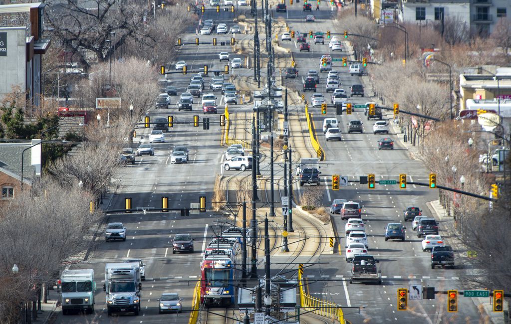 A section of 400 South, an arterial street, with six lanes of traffic in both directions and the light rail train running down the center of the street.